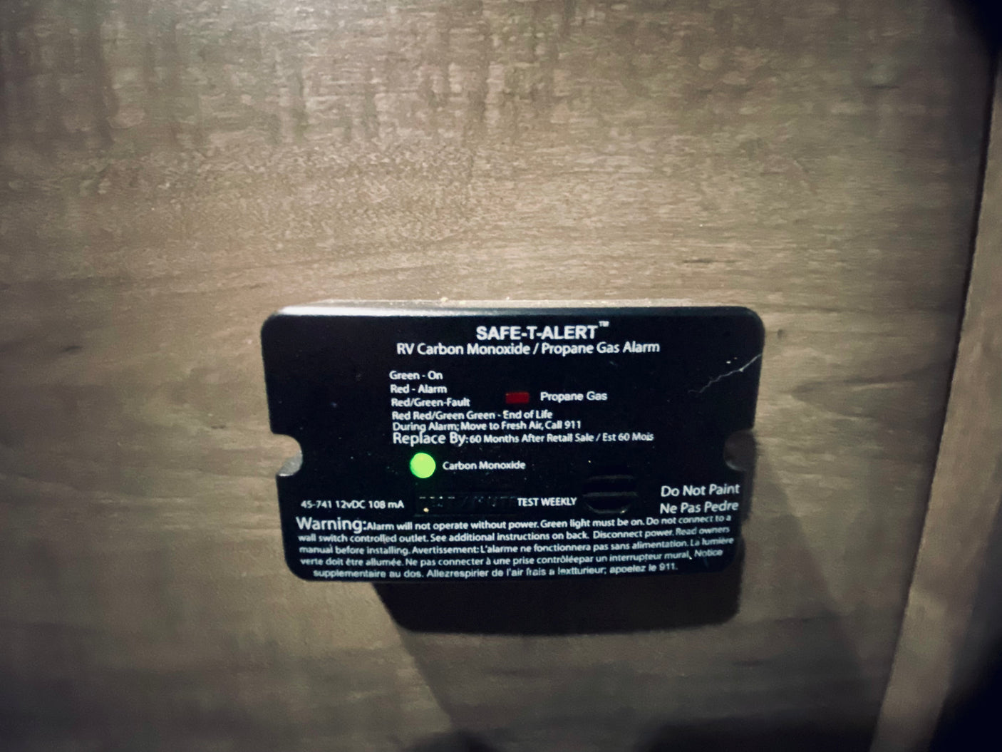 An RV rental's SAFE-T-ALERT Carbon Monoxide/Propane Gas Alarm, with its green light on, indicating active safety monitoring.
