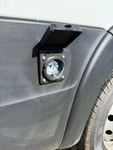 RV rental camper van's shore power inlet. Open, showing the electrical connection for external power hookup.