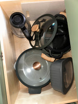 RV rental kitchen drawer: Organized pots, pans, kettle, and a ribbed container for compact storage.