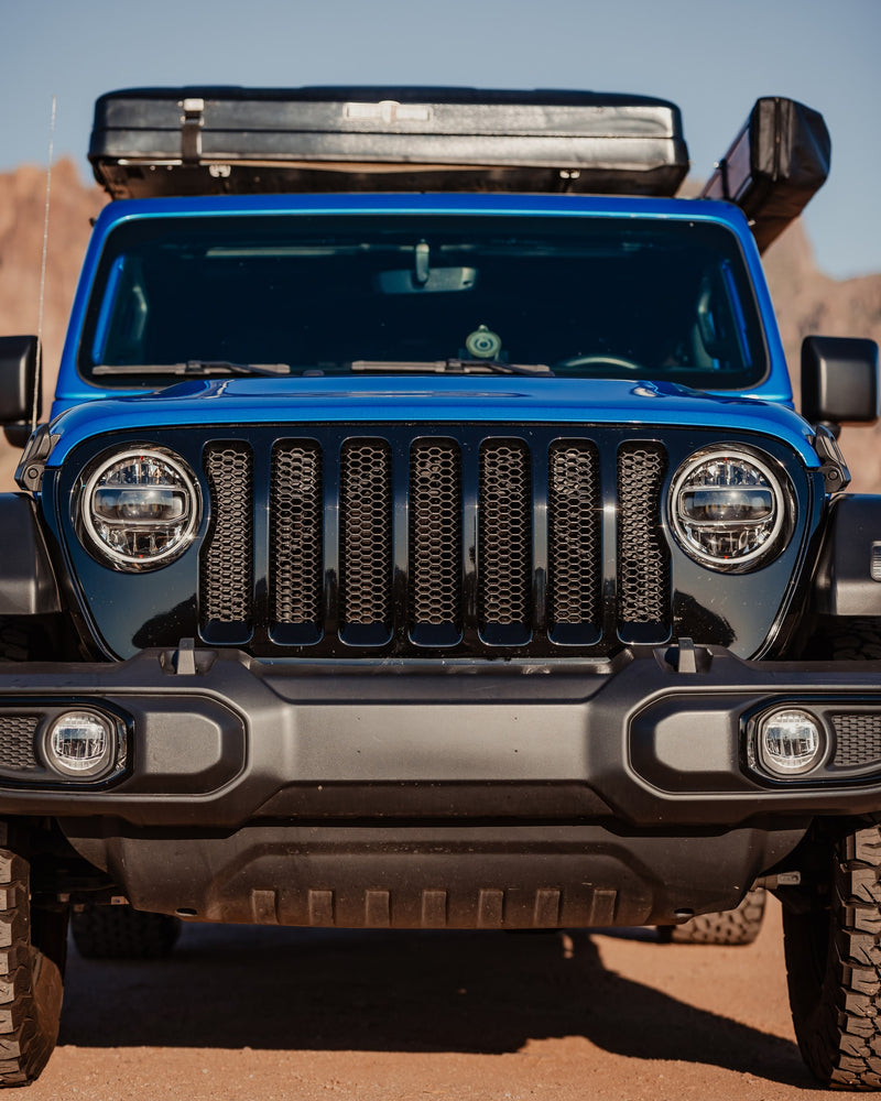 Close-up frontal view of a blue Jeep Wrangler with a rooftop tent, ideal for your next RV rental adventure. — photo 3