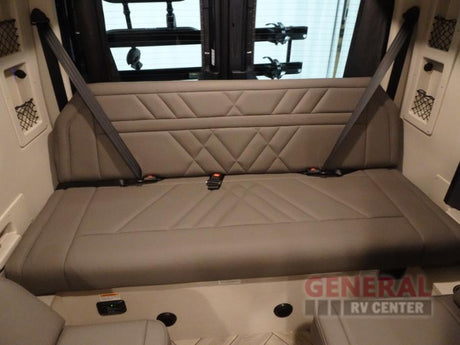 Spacious RV rental interior featuring a comfy light grey bench seat with diamond stitching & three seatbelts for safe travel.
