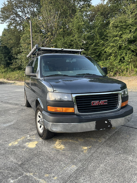Gray GMC camper van with rooftop solar and awning, perfect for your next RV rental adventure!