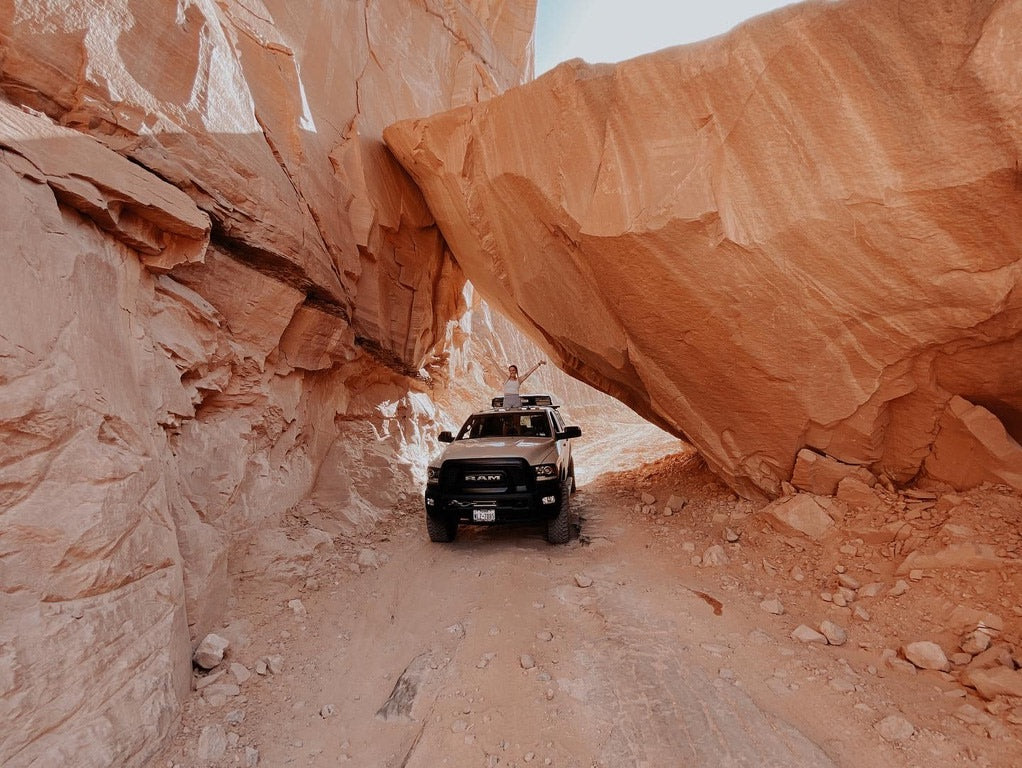 Off-road truck navigates a stunning orange slot canyon. Ideal for an epic adventure trip; consider an RV rental for the journey.