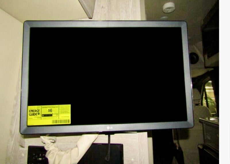 This photo shows a black-screen flat-panel TV with an energy sticker, mounted inside an RV rental for entertainment. — photo 8