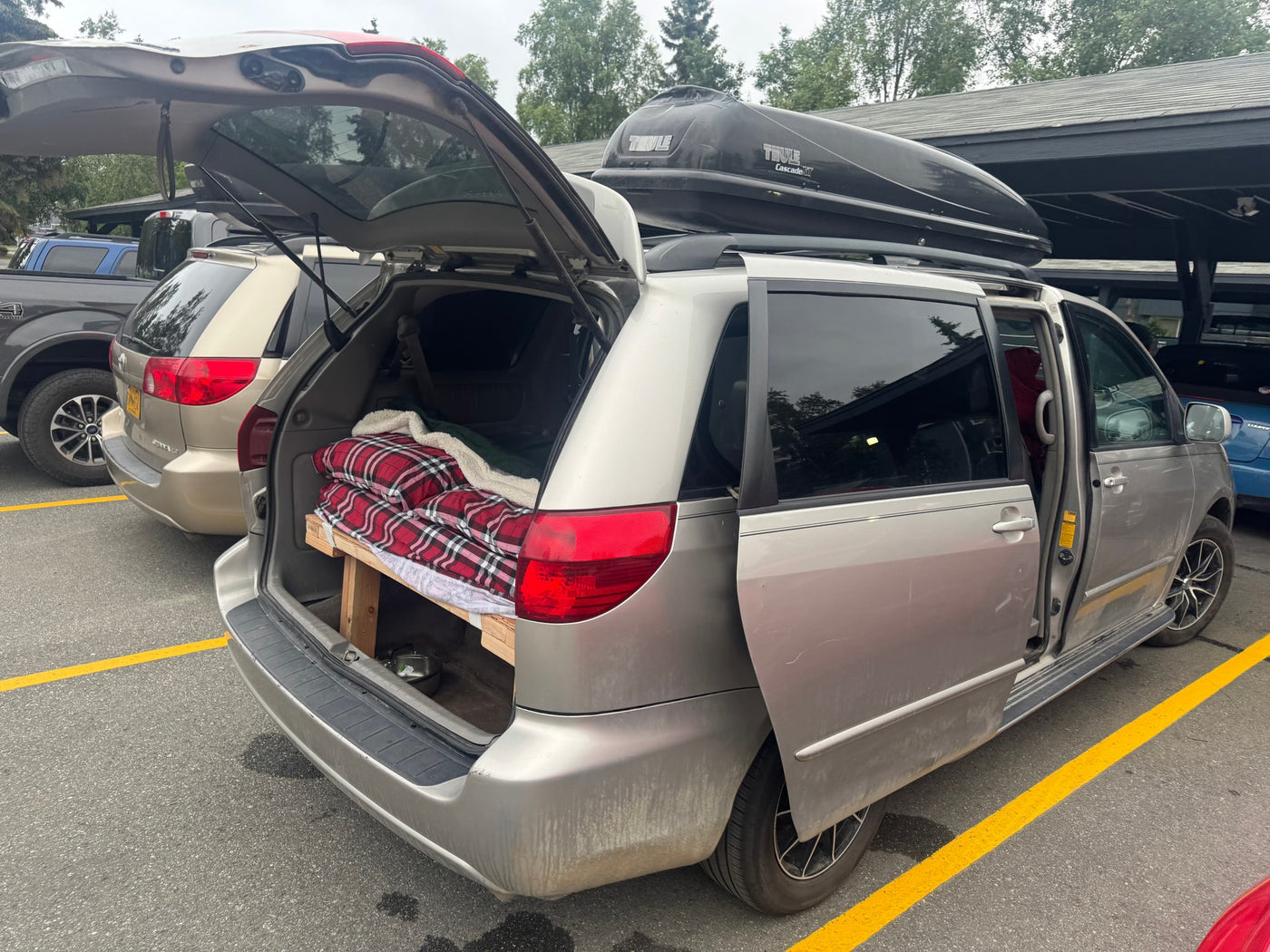  and sky from the open hatch. Perfect for a road trip!|Front of a wet silver Toyota minivan with roof box — photo 10