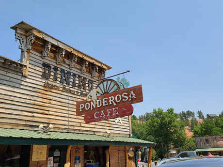 A rustic wooden building, the Ponderosa Cafe, with a large 'Dining' sign, an inviting stop on your RV rental road trip.