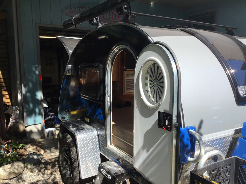 Compact teardrop travel trailer RV rental with open door revealing interior and step. Ready for your next trip! — photo 9