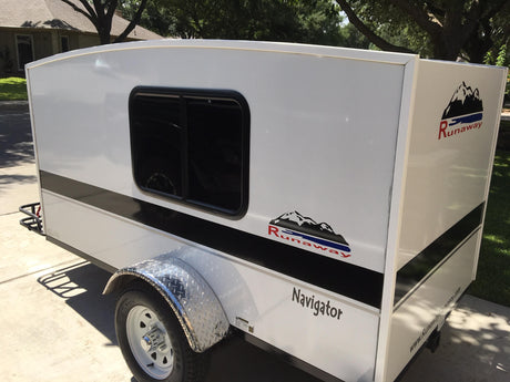 White Runaway Navigator compact camper, ideal for RV rental. Features a window, black stripe, & diamond plate fender.