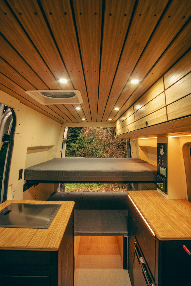  and ambient lighting for comfortable travel.|Organized storage in this RV rental camper van rear features illuminated pull-out drawers — photo 7