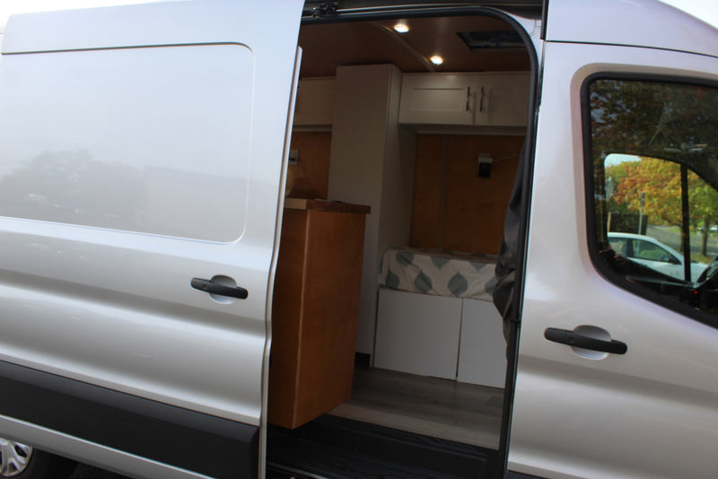 overlooks the Hollywood sign and Los Angeles cityscape.|A modern silver Ford E-Transit van — photo 3