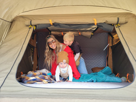 Family fun inside a comfortable tent. An RV rental adventure creating happy memories for mom, toddler, and baby.