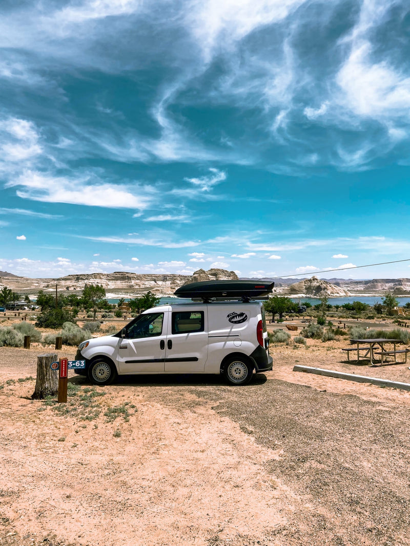  with a serene lake & mountain view from the open rear doors.|White RV rental camper van at lakeside campsite 3-63 — photo 3