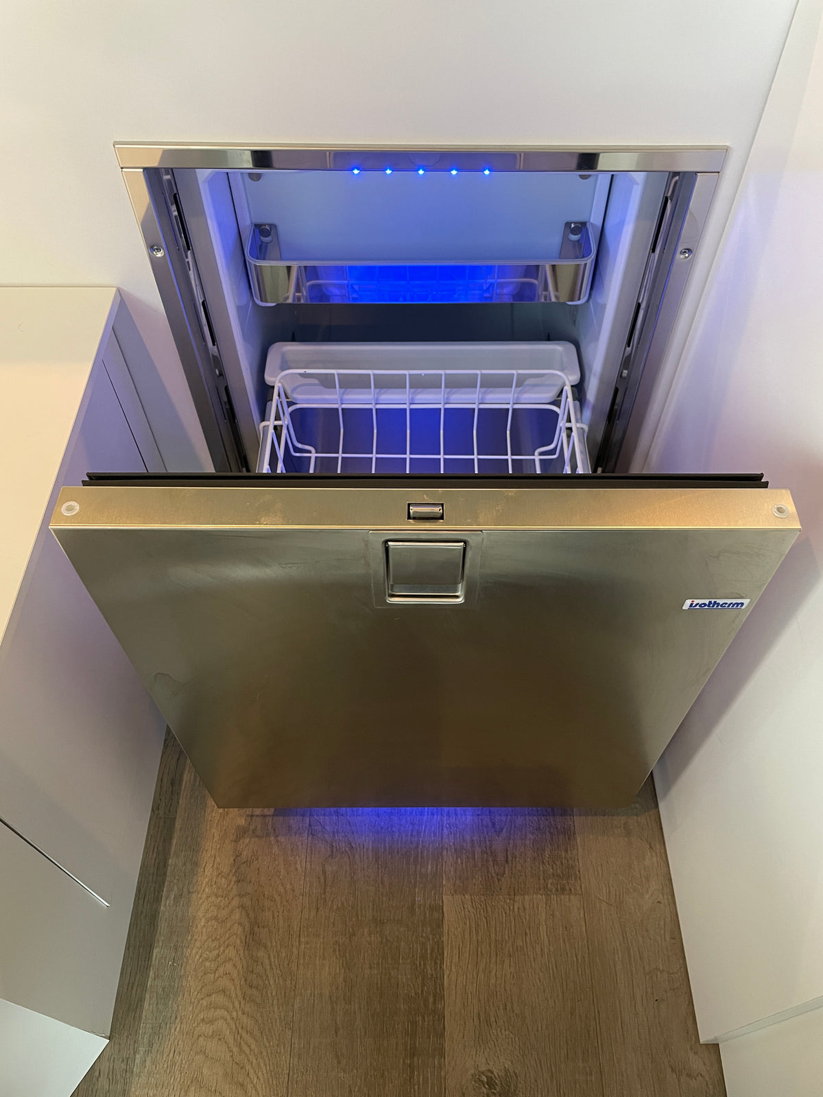 Opened Isotherm stainless steel drawer fridge/freezer with blue lighting, a space-saving appliance in this RV rental. — photo 7