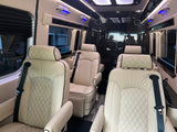 Inside a luxury rv rental: plush cream quilted seats with black trim, blue accent lights, and sleek dark paneling create a lavish cabin.