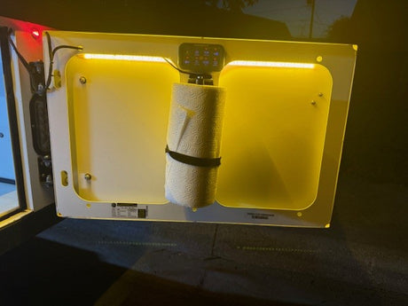 RV rental: Illuminated compartment door with essential paper towels & control panel for easy access on your trip.