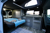 Spacious camper van interior for rv rental, showing a comfy bed, compact kitchen, and pop-top for bright adventures.