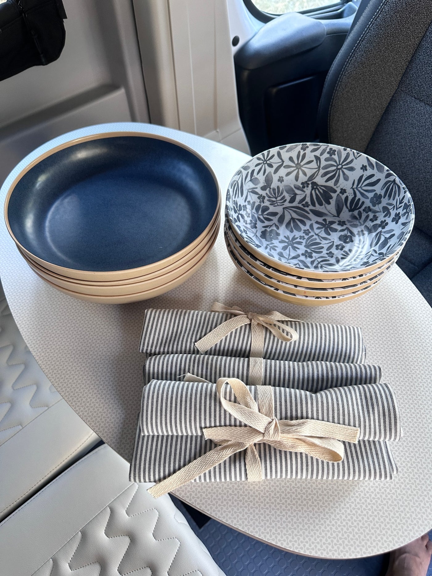  and blue patterned flooring.|Spacious RV rental interior features white padded bench seating — photo 9