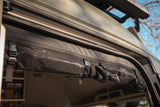RV rental: Inside view of an overhead fabric storage system with buckles, perfect for organized van adventures.