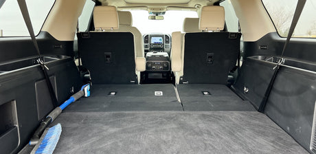 Spacious SUV interior, seen from the rear cargo area with third-row seats folded flat, perfect for rv rental trips.