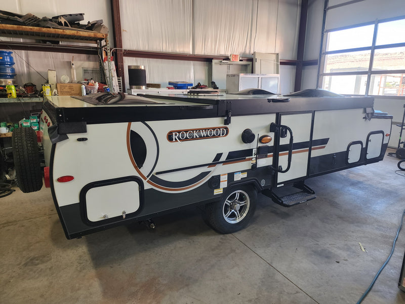 Rockwood pop-up camper, ready for RV rental, parked indoors. This compact recreational vehicle features a sleek design. — photo 10