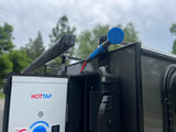HOTTAP portable water heater & blue shower head mounted on an RV rental, ready for refreshing outdoor showers under a cloudy sky.