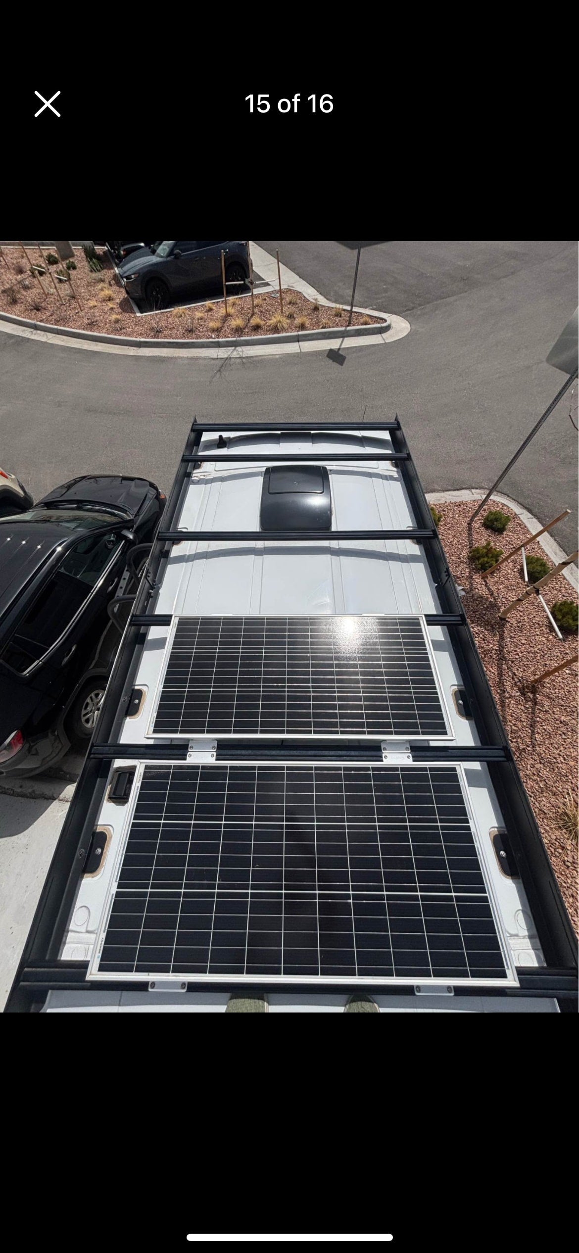RV rental roof setup: two large solar panels, roof fan, and sturdy rack for off-grid power.