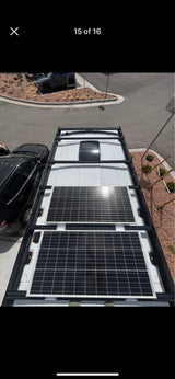 RV rental roof setup: two large solar panels, roof fan, and sturdy rack for off-grid power.