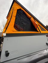 Bright orange Go Fast Campers (GFC) rooftop tent on a truck camper, ready for your next rv rental adventure.