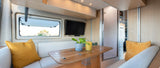 Enjoy this modern rv rental interior: a bright dining area with comfy seating, a window with a view, and a wall-mounted TV.