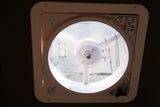 Inside an RV rental: a Maxxair ceiling fan and vent with controls, screen, and warning label, providing air flow.