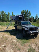 RV rental: Dark grey Jeep with deployed rooftop tent & ladder. Perfect for camping adventures!
