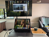 RV rental mobile office/entertainment setup: A laptop and external monitor playing a video, with tea and a child seat inside.