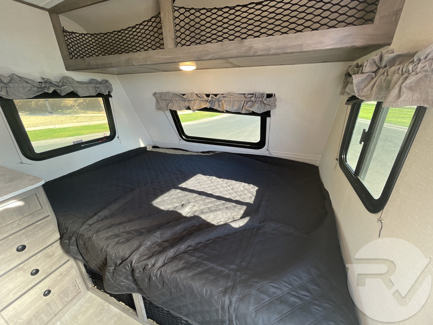 Spacious RV rental bedroom features a comfy bed, scenic windows, and handy overhead bunk storage. — photo 13