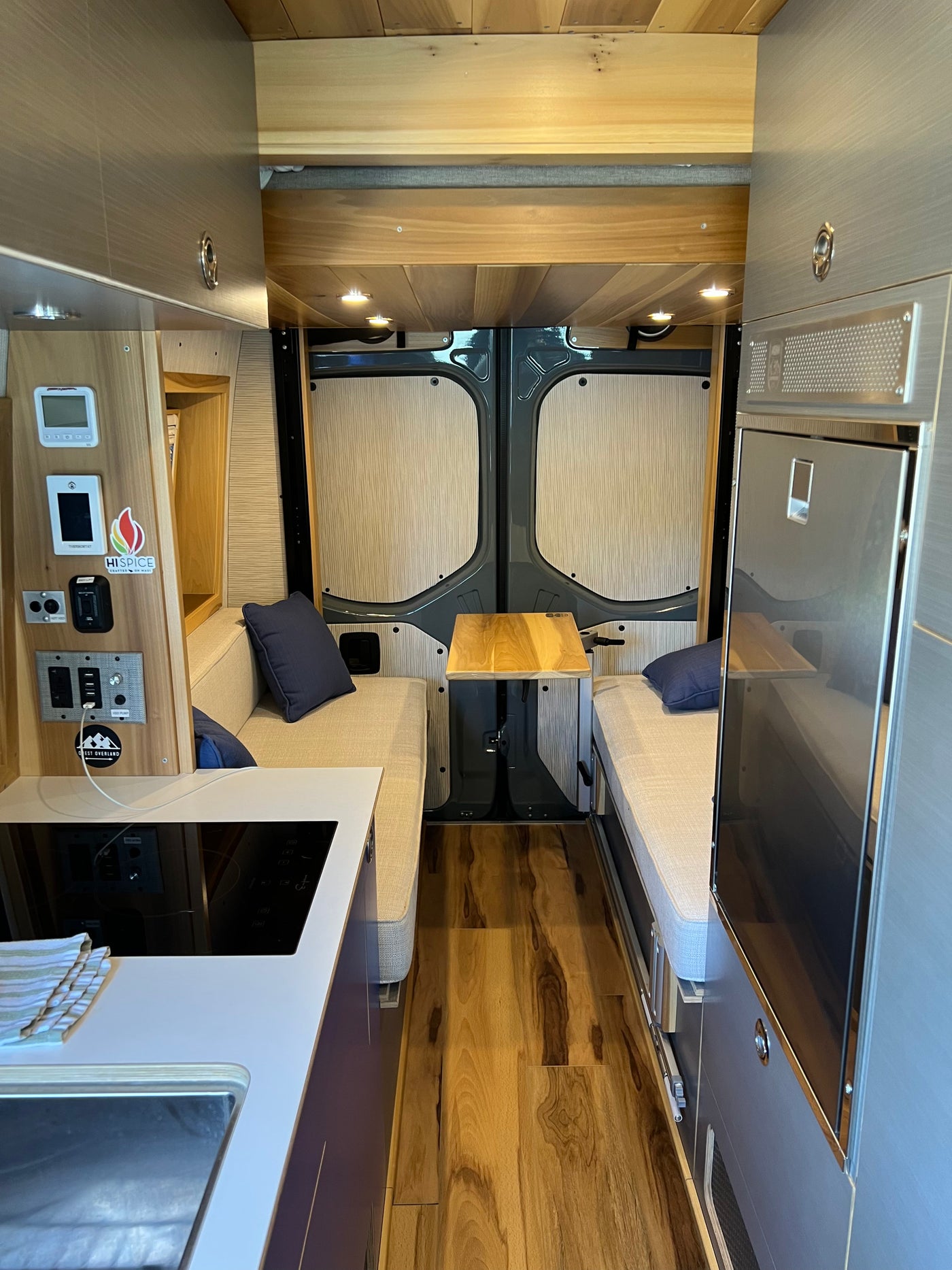 Experience comfort in this modern rv rental camper van interior. Featuring a kitchenette, sleeping benches, and a cozy dining area. — photo 6