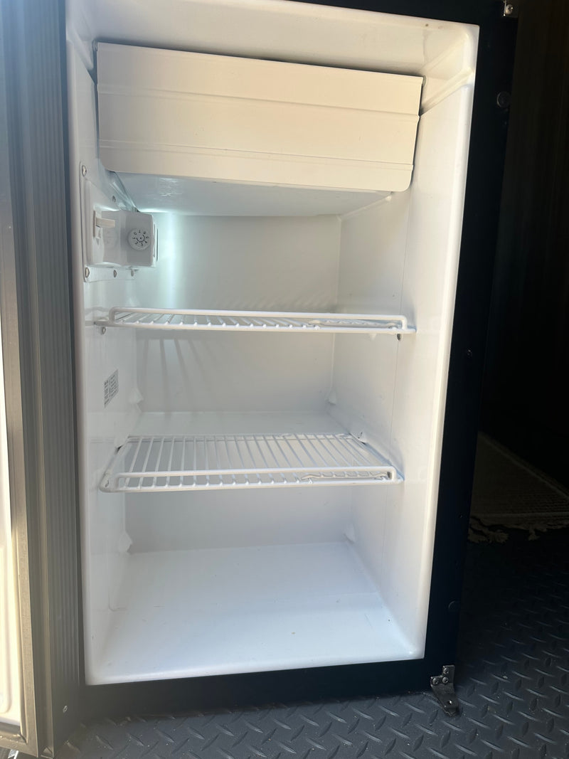 Clean, empty mini-fridge interior with shelves & freezer unit, ready for guests in this rv rental. — photo 9