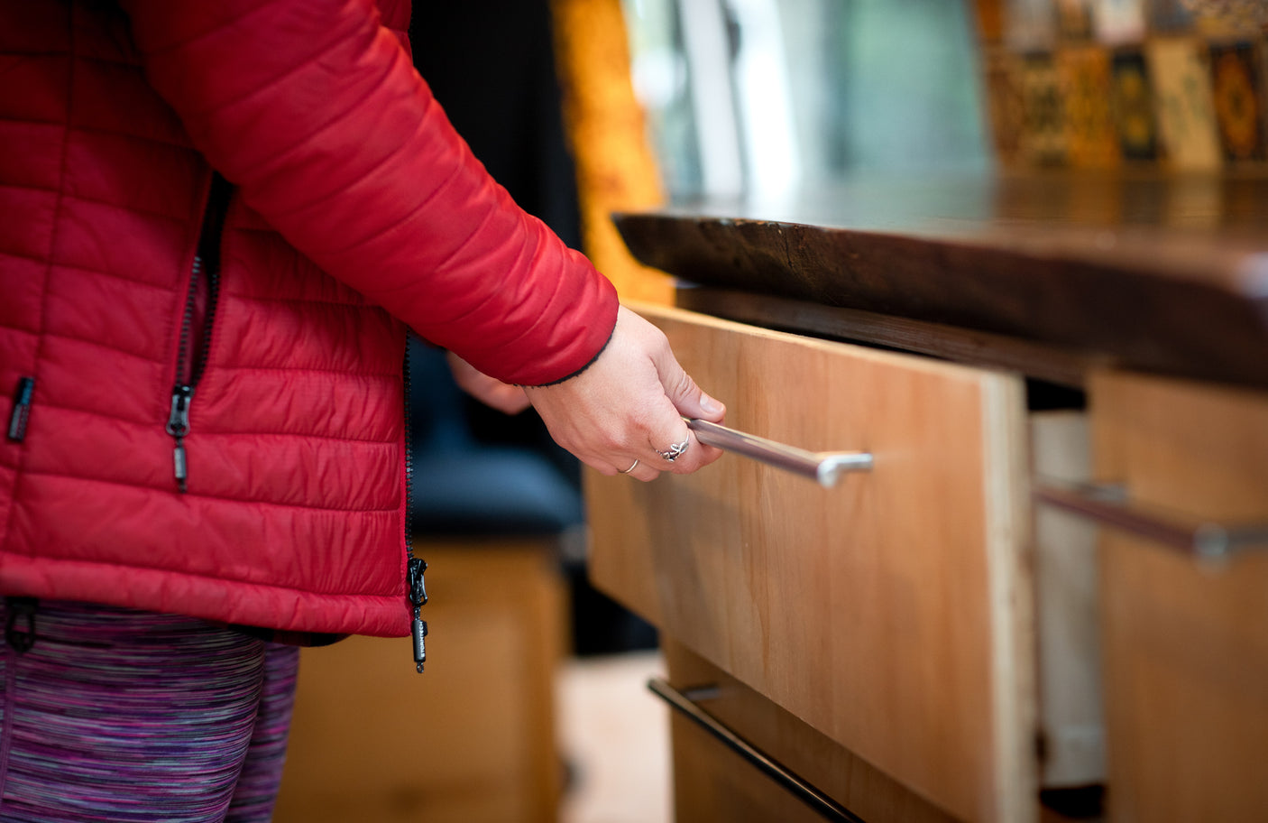 Hand opening a drawer in an RV rental, showcasing practical storage for comfortable travel.
