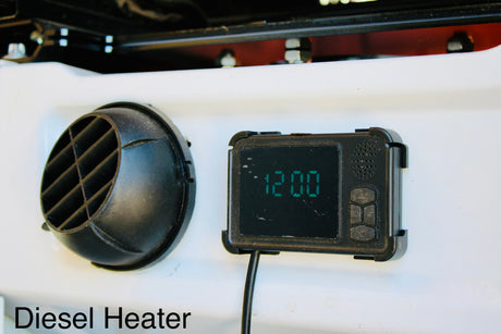Ensure warmth in your RV rental with this diesel heater's vent and digital control panel, displaying 12:00.
