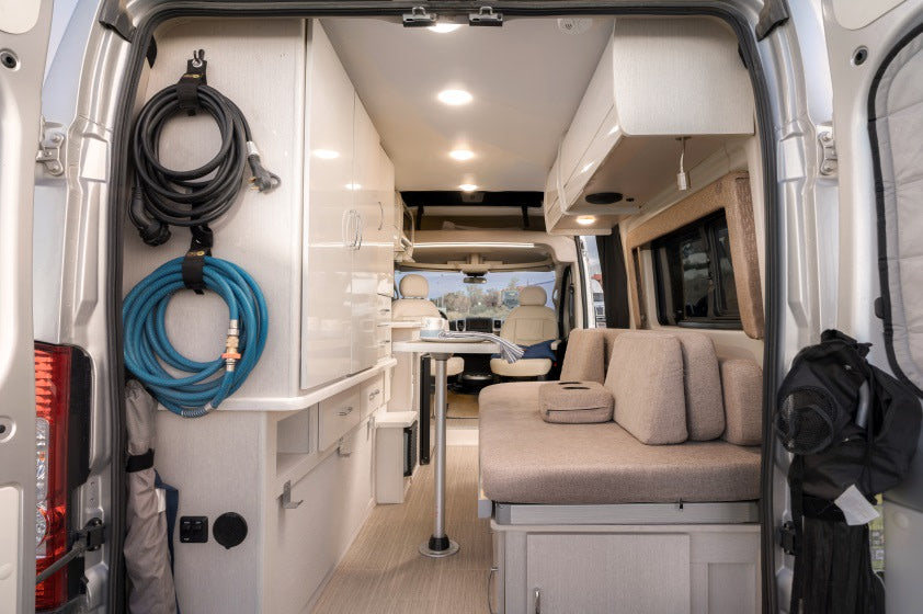 Spacious, modern RV rental interior with convertible seating, dining area, and ample storage, ideal for travel.