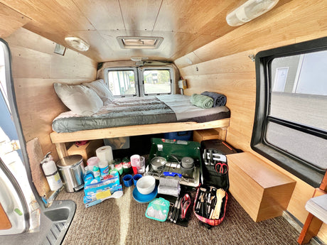 Explore this RV rental's organized interior with a comfy bed, camp kitchen, and all necessities for your trip.