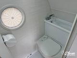 Compact RV rental bathroom: toilet, sink, and a round window with a pleated shade. Perfect for road adventures.