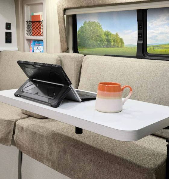 Enjoy productivity on the road in your RV rental. A laptop and mug on a table face a calming nature view from the window. — photo 11