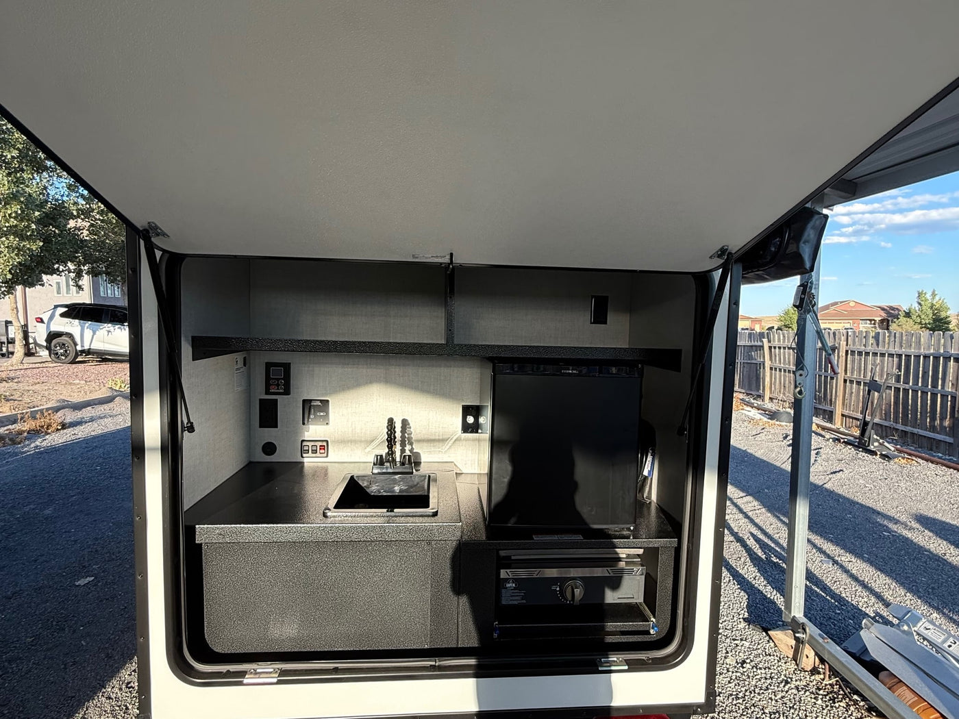  rugged spare tire for adventure.|Ember RV rental. Close-up of the black and yellow Ember logo and text on a light blue vehicle surface.|Rear of Ember RV trailer — photo 5