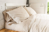 Plush, light-colored bedding makes a comfortable bed inside this RV rental. Wall outlets and dimmer switches offer convenience.