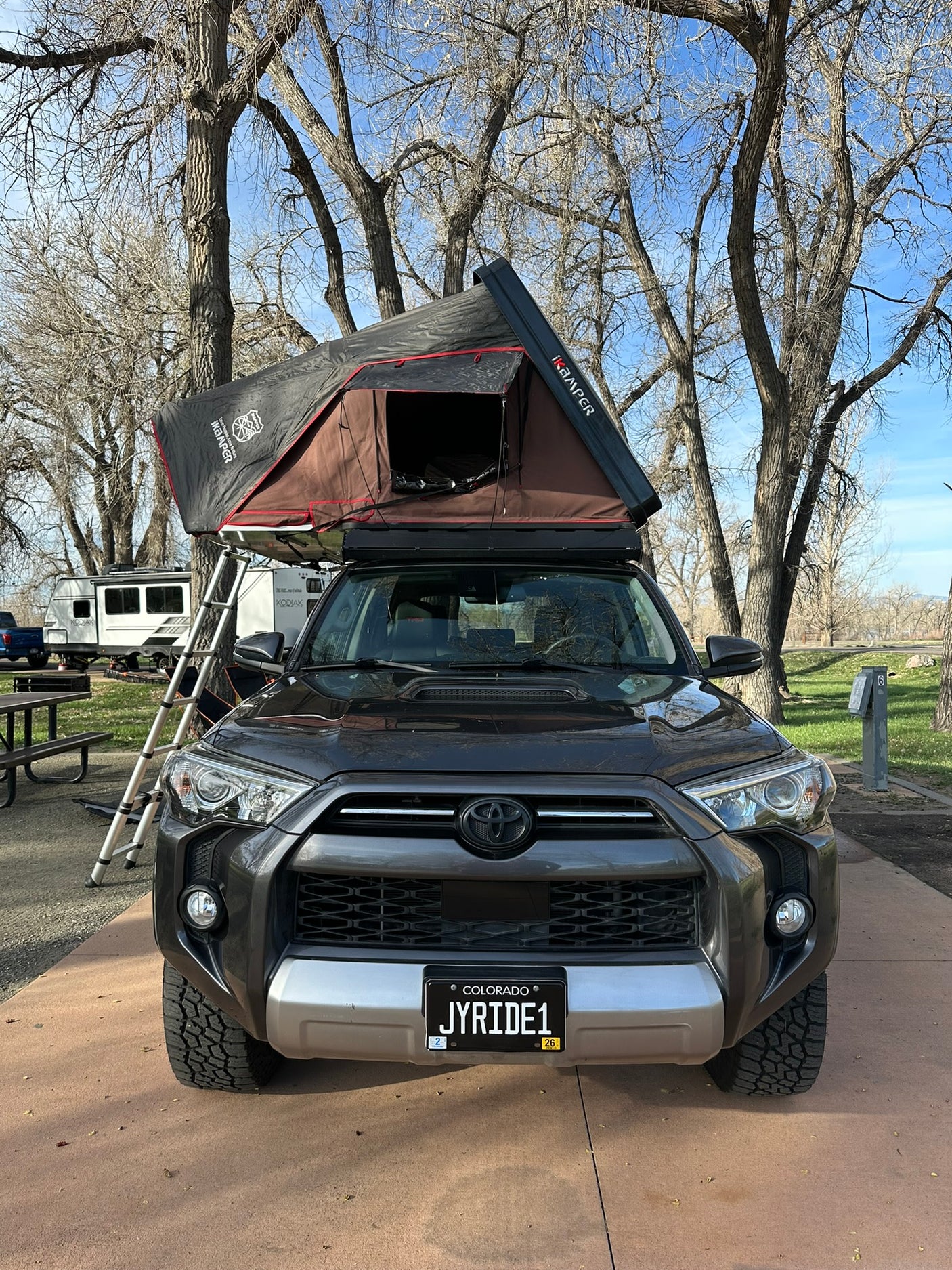 Ready for adventure: a dark grey 4Runner SUV with a rooftop tent, ideal for camping trips, a unique RV rental alternative.