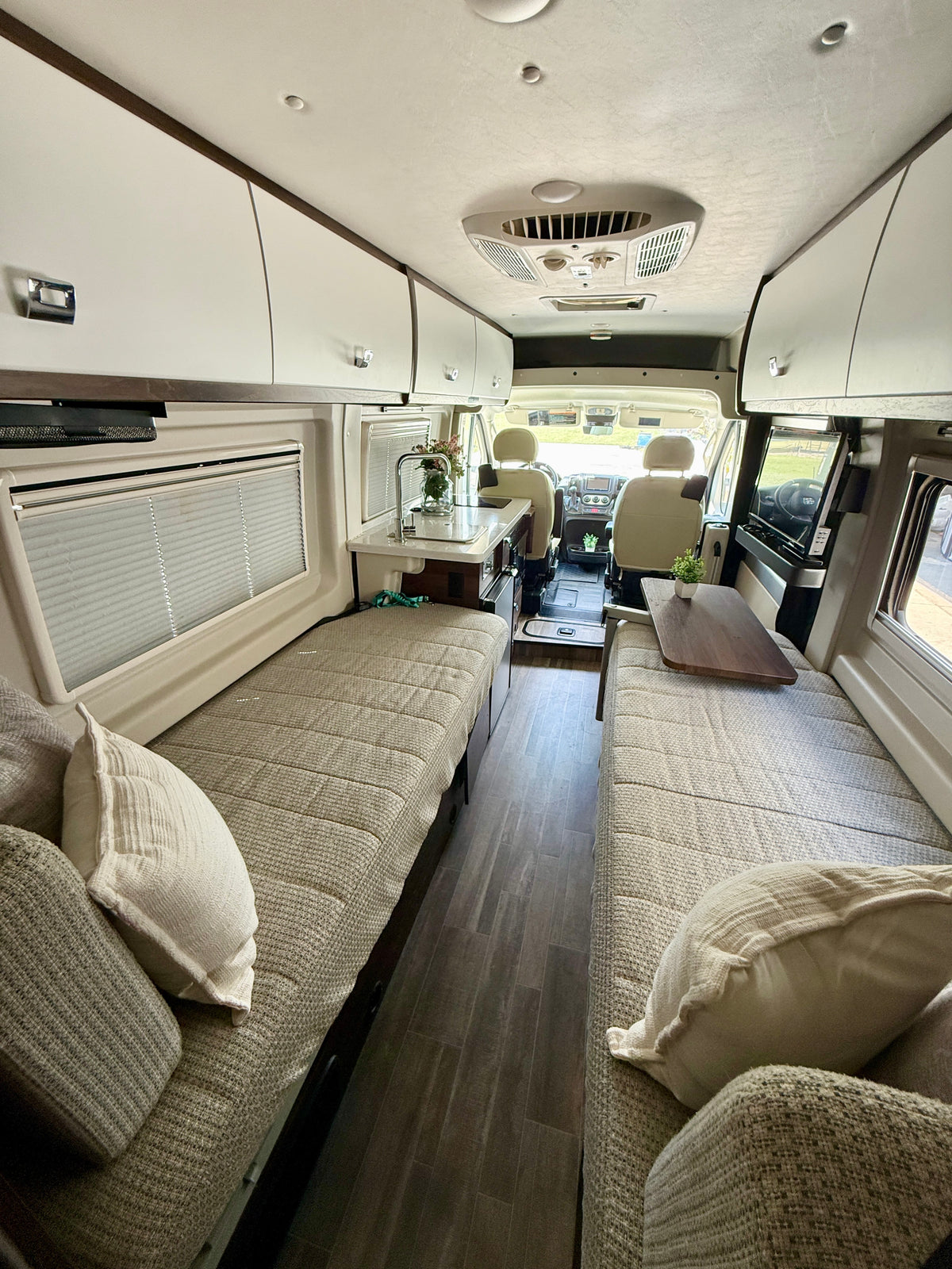 This rv rental's spacious interior features twin sleeping areas, a kitchen, and a TV, all designed for comfortable travel. — photo 14