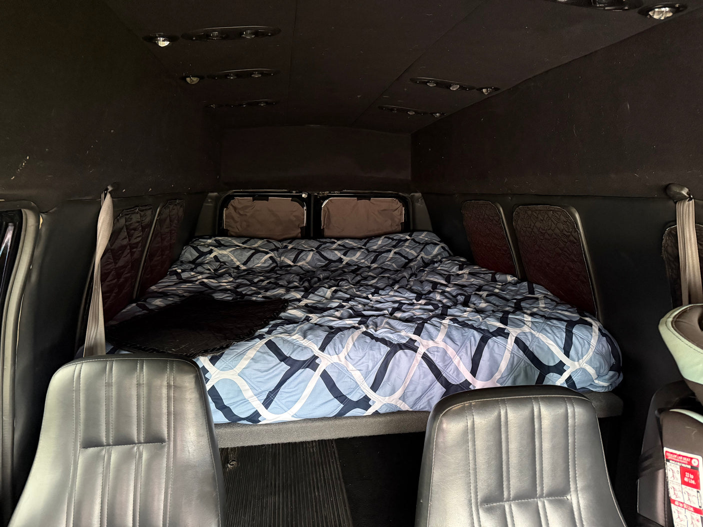 Cozy RV rental interior with a comfortable bed and front seating, ideal for mobile adventures and road trips.