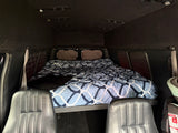 Cozy RV rental interior with a comfortable bed and front seating, ideal for mobile adventures and road trips.