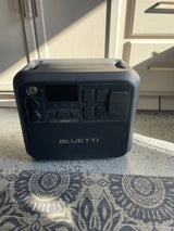 Dark gray Bluetti AC200L portable power station, great for rv rental, providing off-grid energy, on a speckled garage floor.