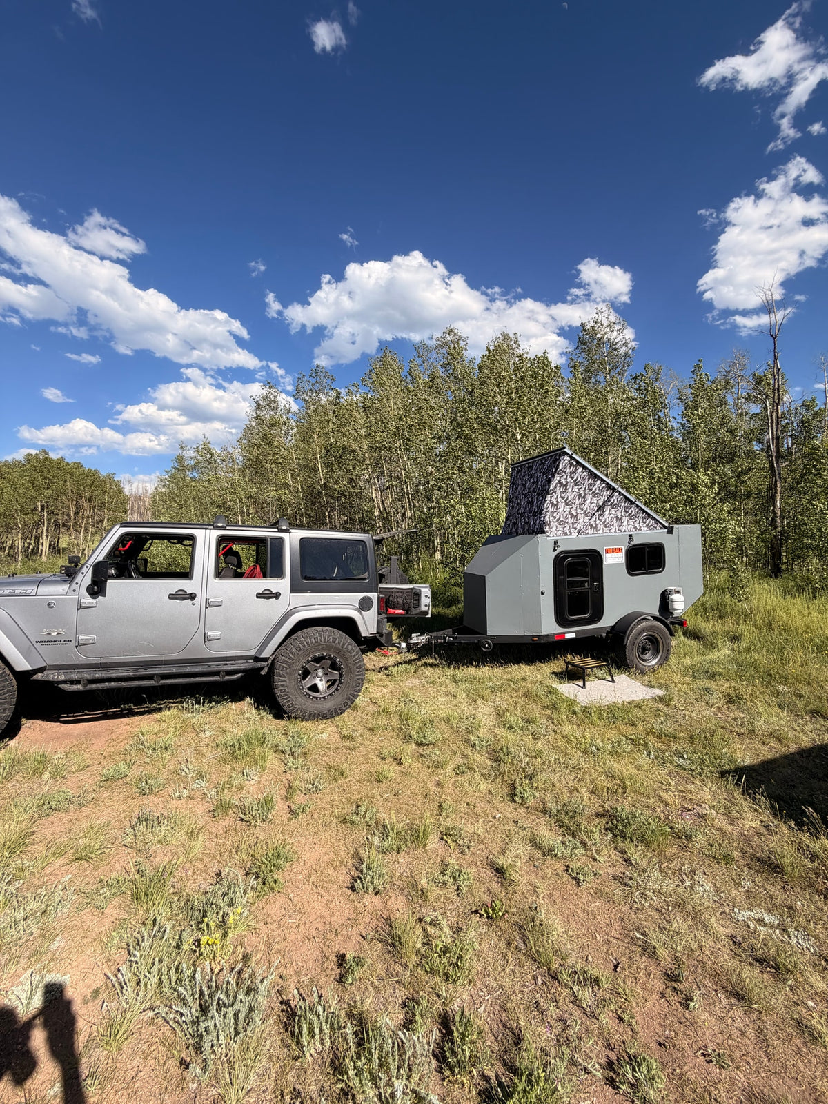 Silver Jeep Wrangler towing a gray off-road camper with pop-top tent (for sale). A rugged RV rental setup ready for nature. — photo 11