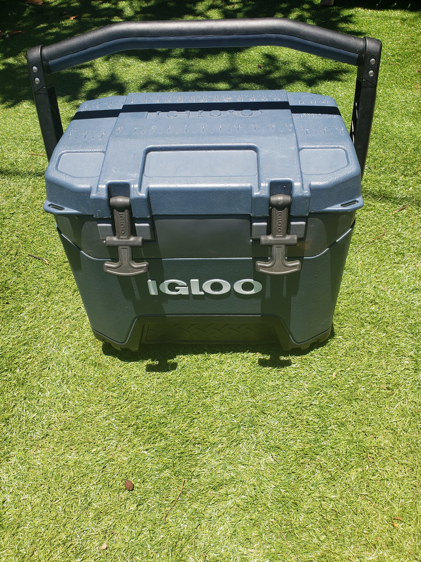 Sturdy Igloo cooler on bright green turf, perfect for your next rv rental outdoor adventure.